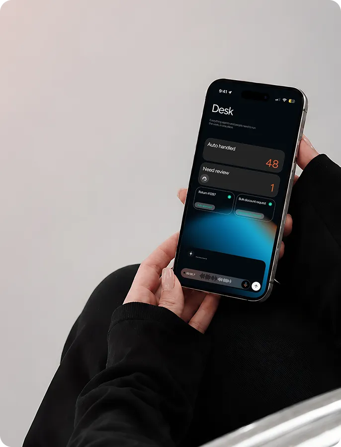 Hands holding a phone showing the Desk app